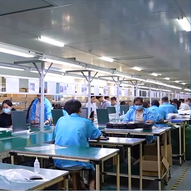 Assembly line at BJYP: workers at benches fitting bezels and panels